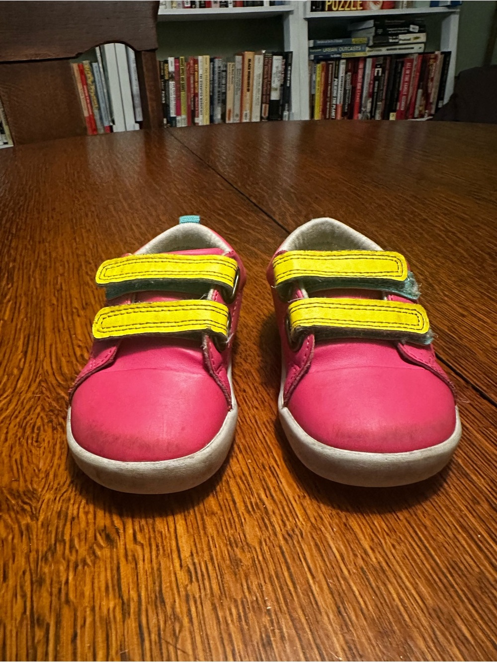 Ten Little pink sneakers with yellow straps.